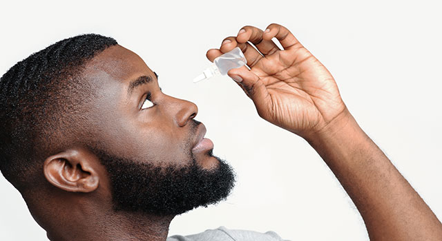 man putting on eye drops